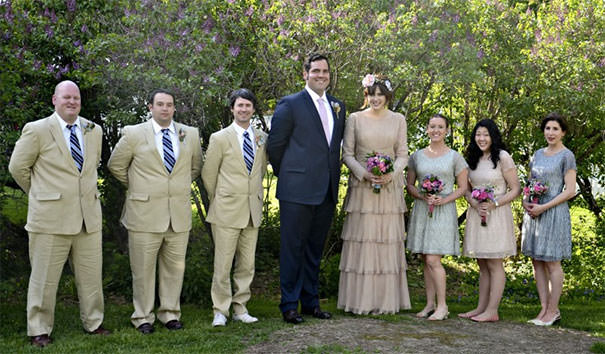 A 6'8" groom and 6'4" bride beside average-sized people