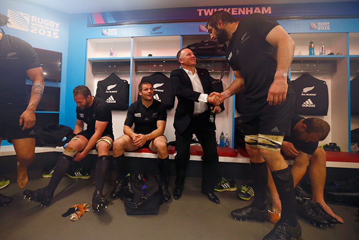 Giant rugby player dwarfs NZ's Prime Minister.