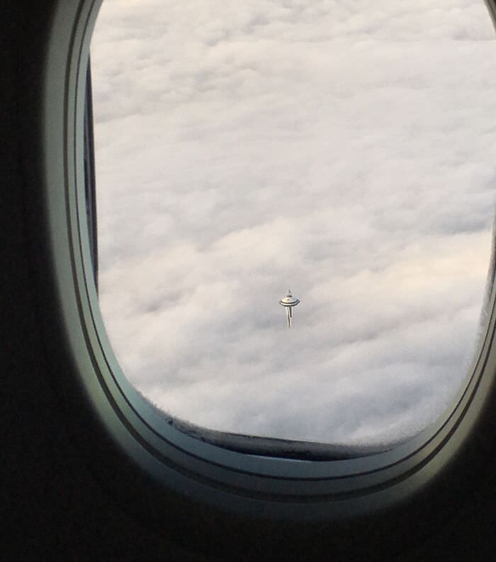 A Space Needle in Seattle over clouds that looks like the cloud city from Star Wars.