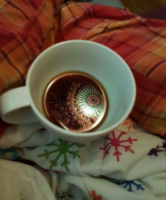 A tapestry above a bed that made a pretty sweet reflection in a coffee this morning.