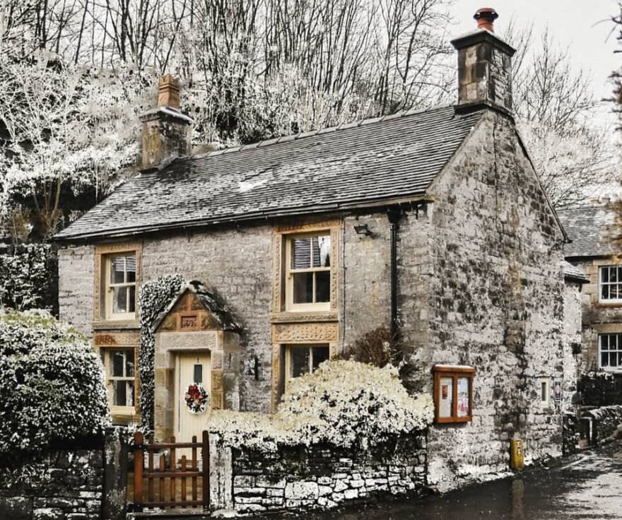 Stone cottage in snow-covered Milldale, Peak District, Derbyshire, England