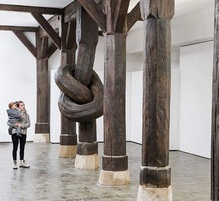 Known for his mind-bending installation art, Alex Chinneck has moved indoors for his latest art installation, tying a 450-year-old wood column into a knot.