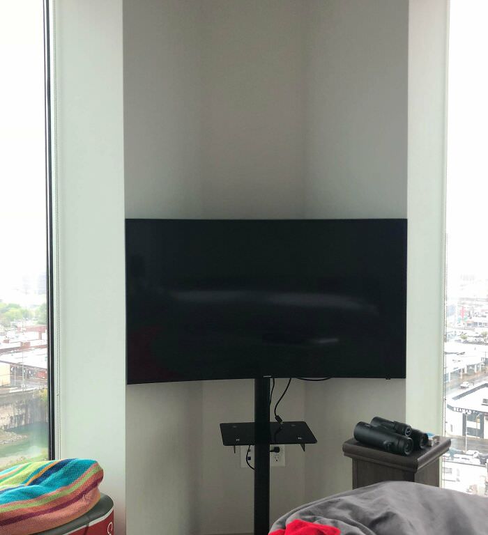 Curved TV perfectly placed in the corner of a bedroom