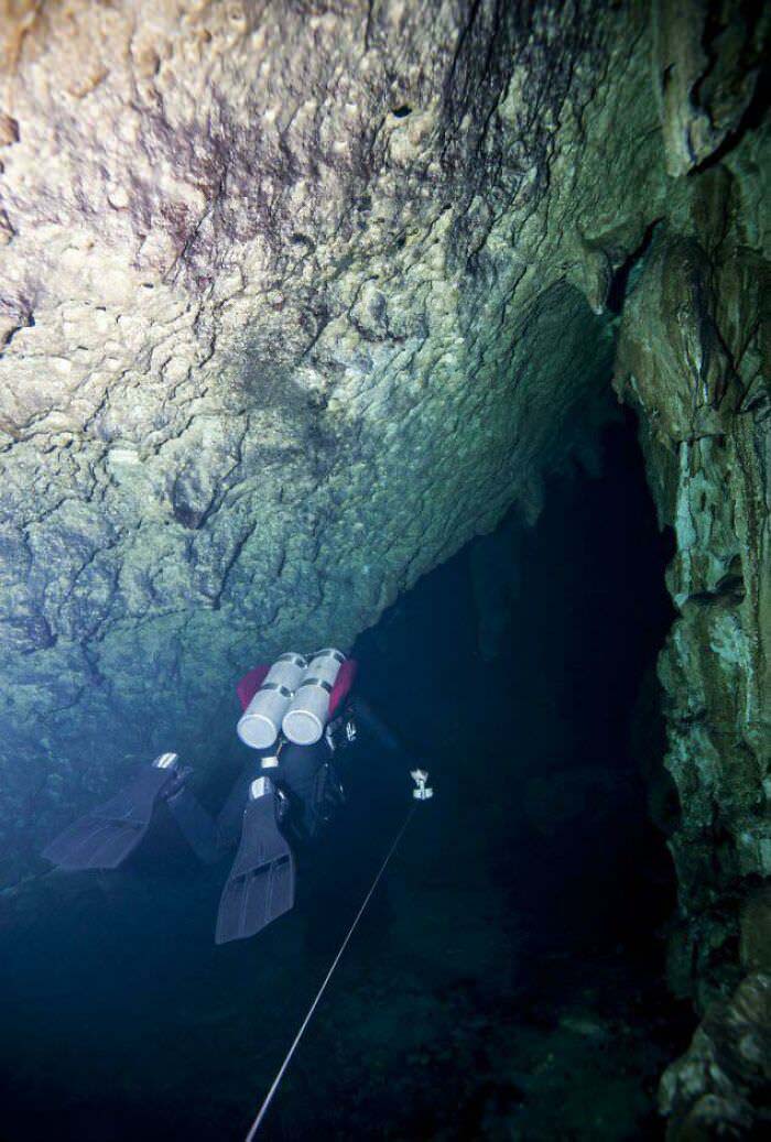 A scuba diver proceeding into an underwater cave