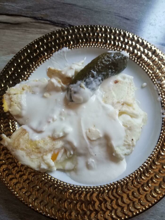 One of my dad's strange food combos - eggs with sour cream on top and a pickle for breakfast.