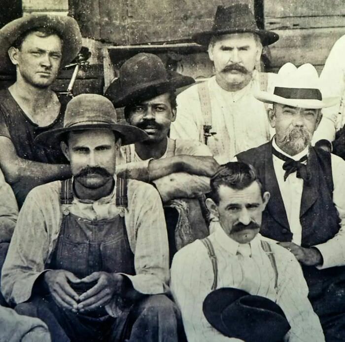 This photo, taken at the turn of the century, shows Jack Daniel (in the white hat) seated next to George Green, the son of Nathan "Nearest" Green, who was the first black master distiller in America.