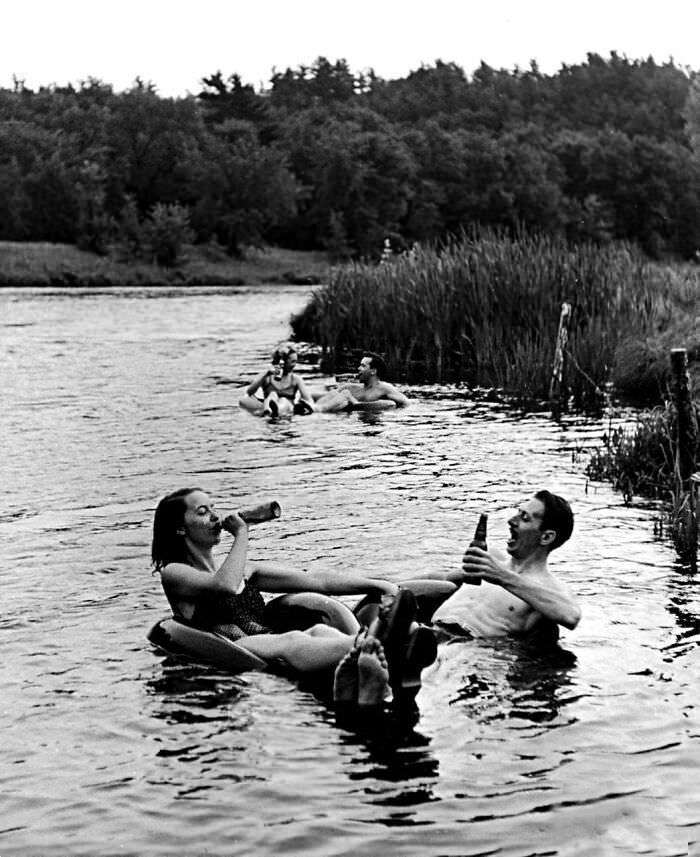 A couple drinking beer at an inner tube floating party on the Apple River, Somerset, WI, 1941.