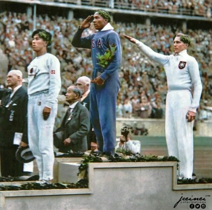 US athlete Jesse Owens salutes during the presentation of his gold medal for the long jump after defeating Nazi Germany's Lutz Long during the 1936 Summer Olympics in Berlin.