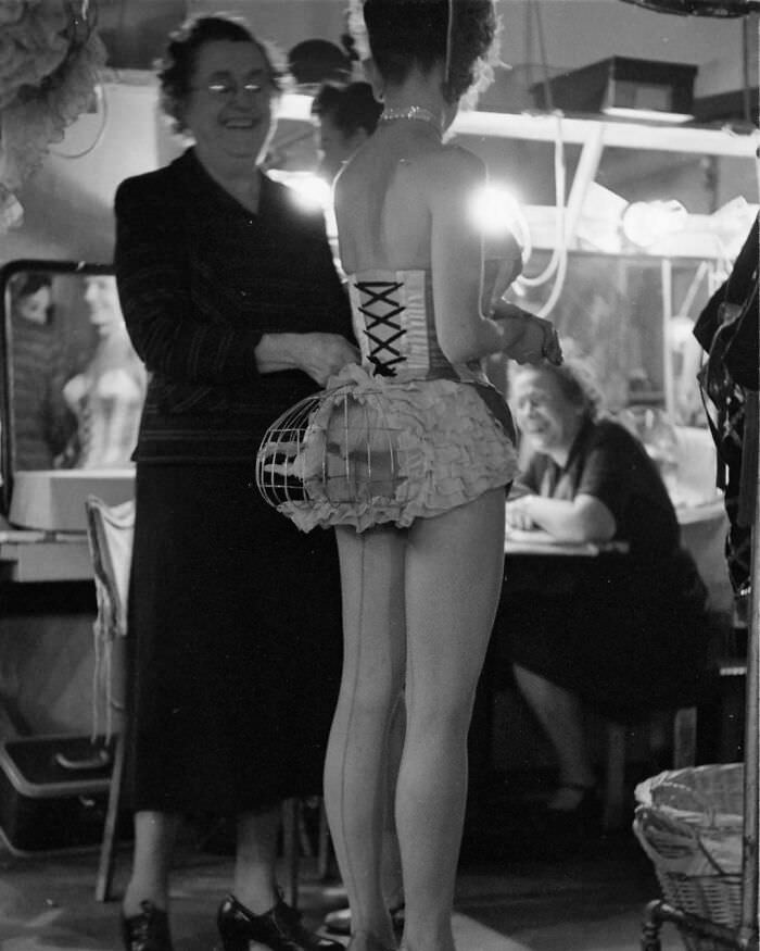 Showgirl with a stuffed bird in a cage on her hindquarters at the Latin Quarter nightclub, New York, 1952.