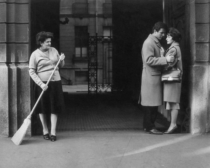 A doorkeeper looking at a couple, 1950s.