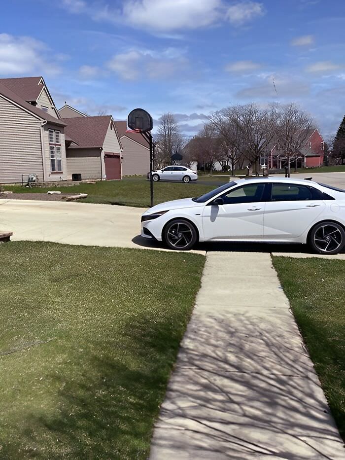 This person has a three-car garage and a large driveway but parks on the sidewalk.