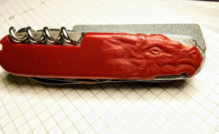 A piece of my Swiss Army knife's handle chipped off, so I carved a dragon's head in the plastic to hide it.