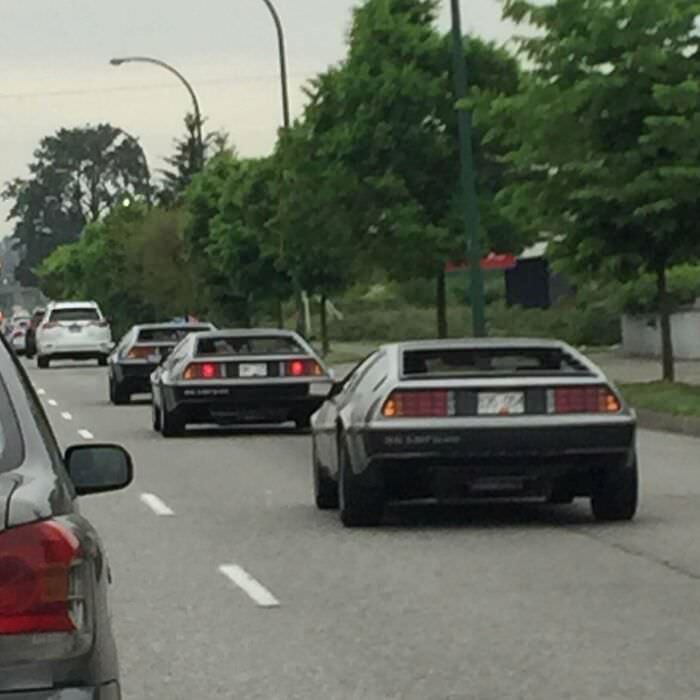 Three DeLoreans driving in a row.