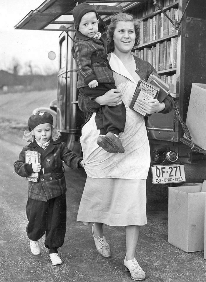 Happy family taking home their book haul from the Cincinnati Library Bookmobile in 1940.