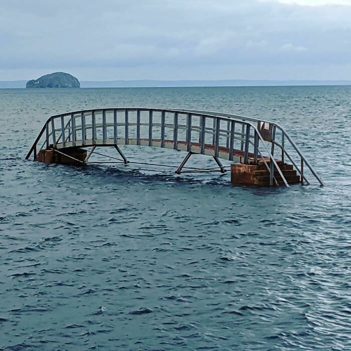 This bridge to nowhere. When the tide is out, it allows beachgoers to cross a stream that cuts across the beach.