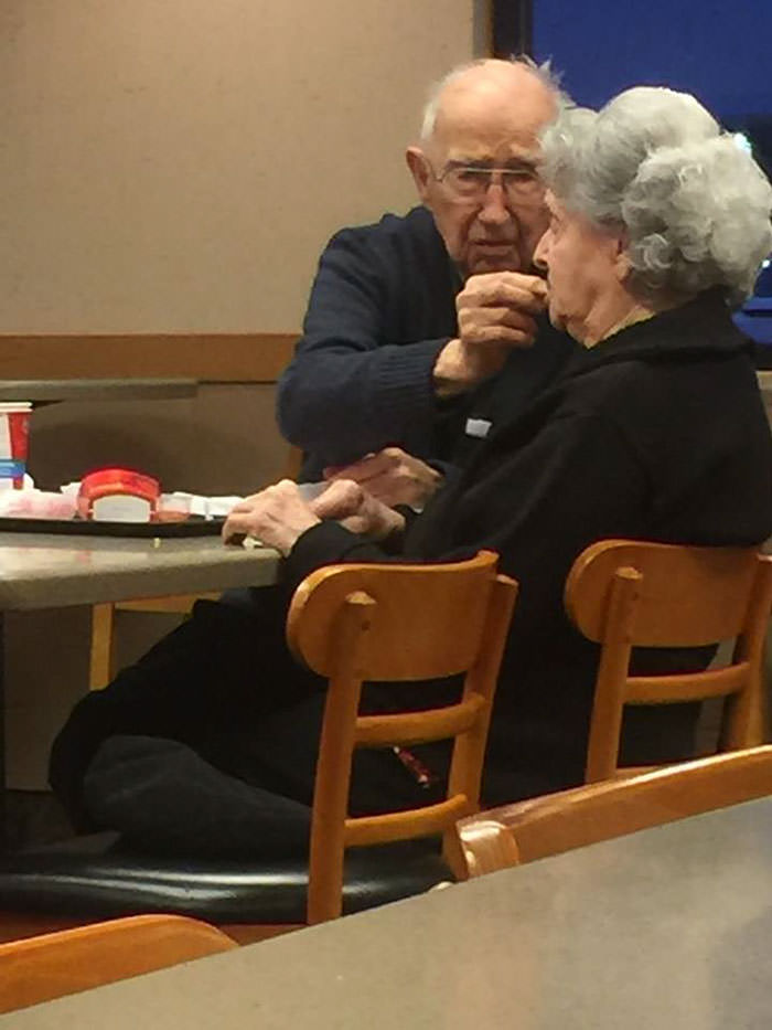 96 years old man feeding his 93 years old wife who is suffering from Alzheimer's. This is their date night.